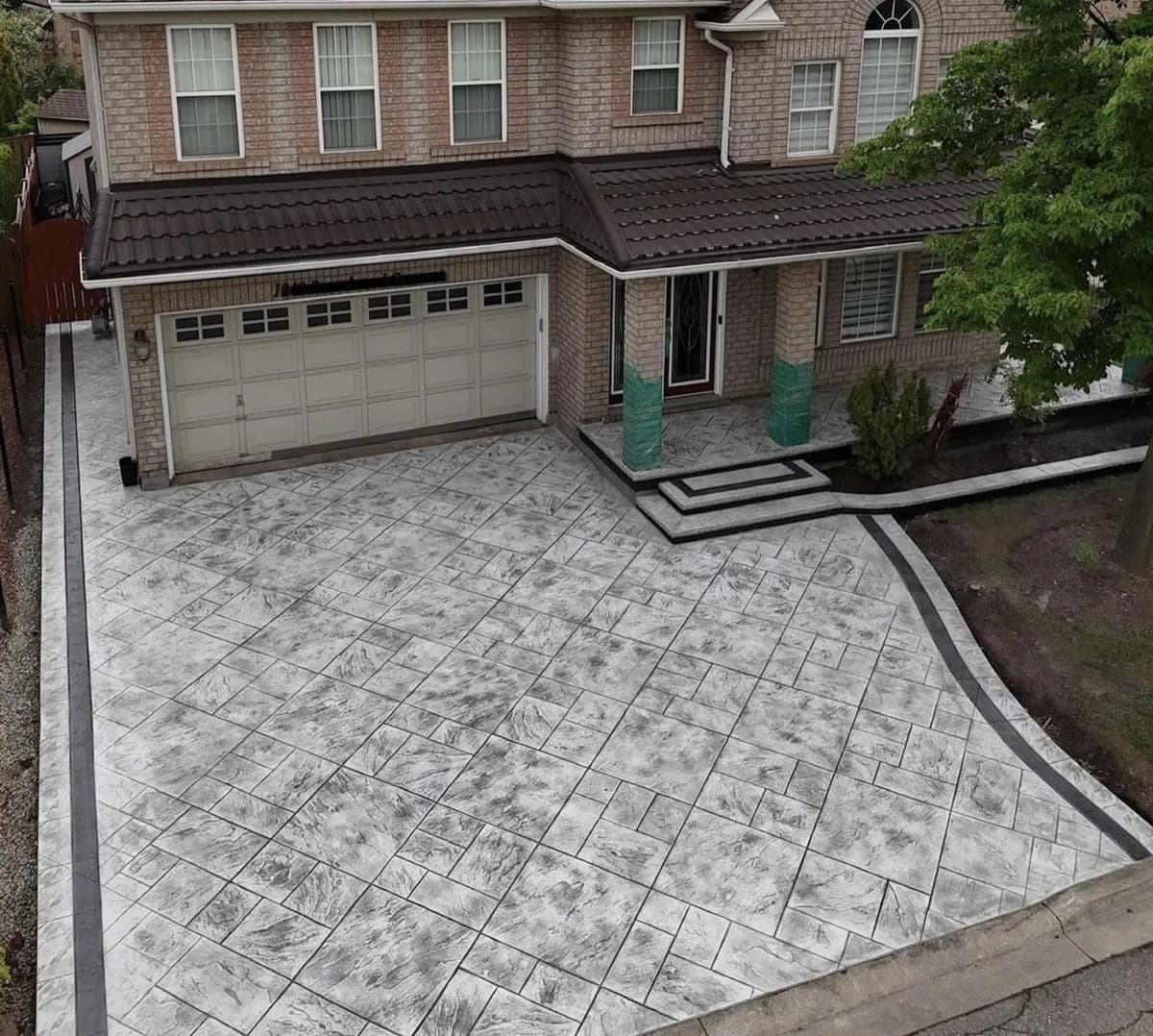 Aerial view of a Highland Park home with a fully replaced stamped concrete driveway and contrasting border