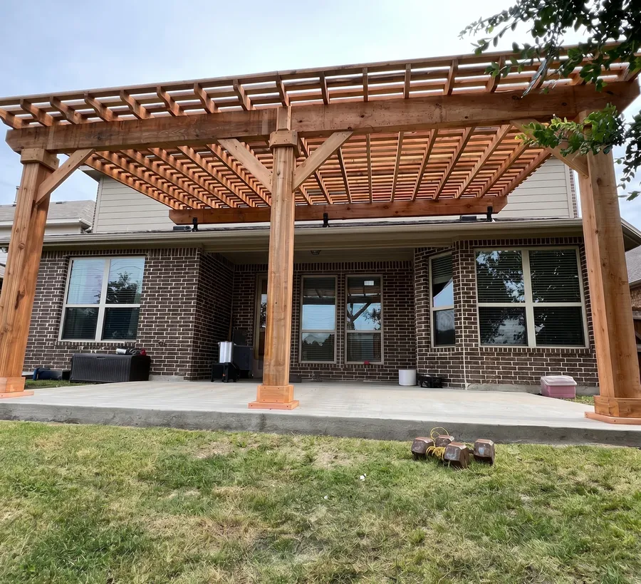 Cedar pergola across the back of a brick home